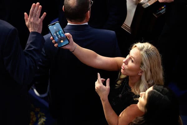 Representative Marjorie Taylor Greene, an ally of Mr. McCarthy, held up a call from “DT.” Representative Matt Rosendale, a McCarthy holdout, appears to brush her off.